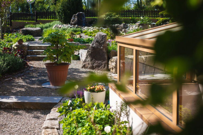 Kieweg und Sitzecke übgeben von Pflanzen