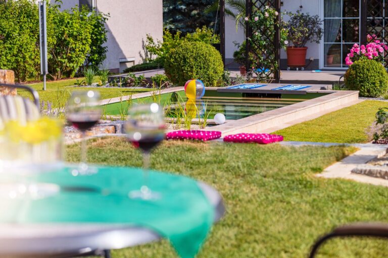 Naturpool mit Terrassentisch im Vordergrund