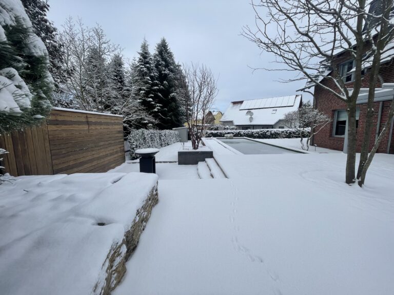 Feuerecke und Naturpool im Winter von Schnee bedeckt