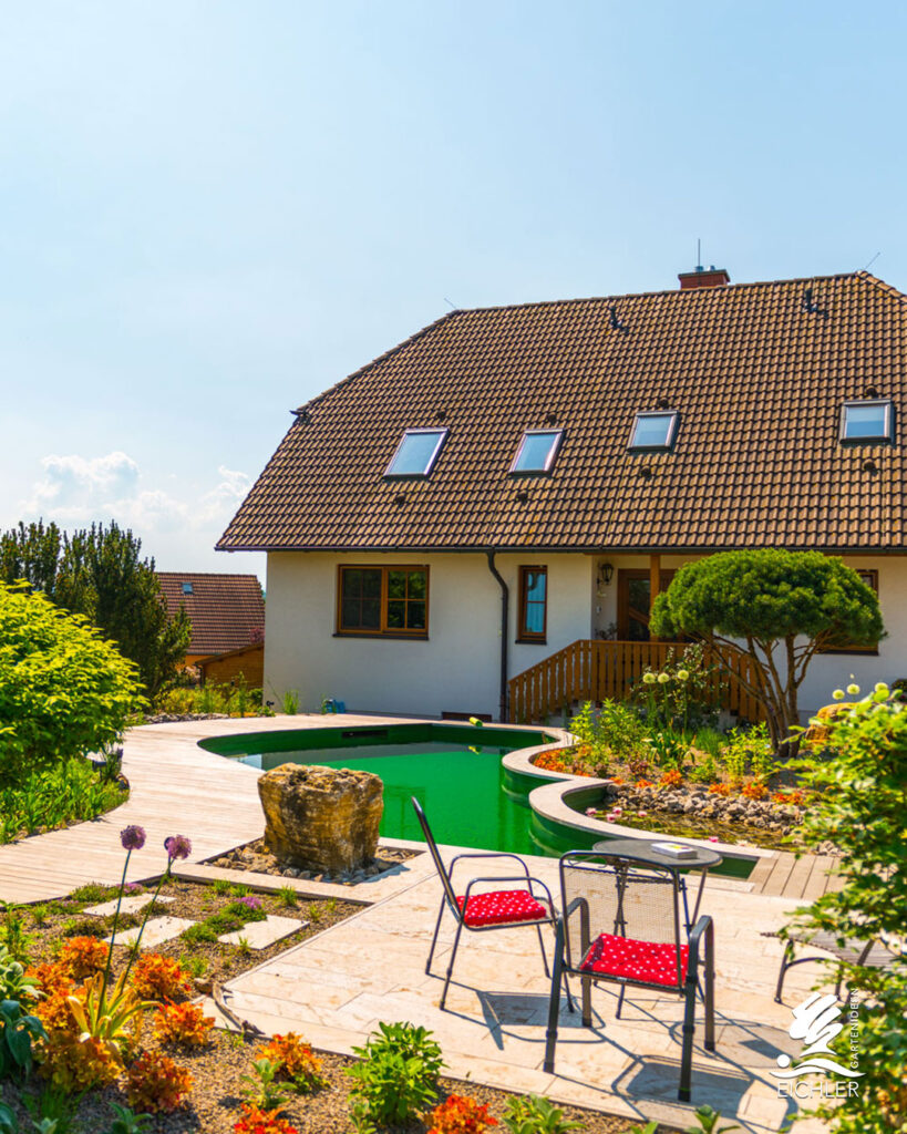 Badeteich im Garten mit Holzterrasse und Sitzecke