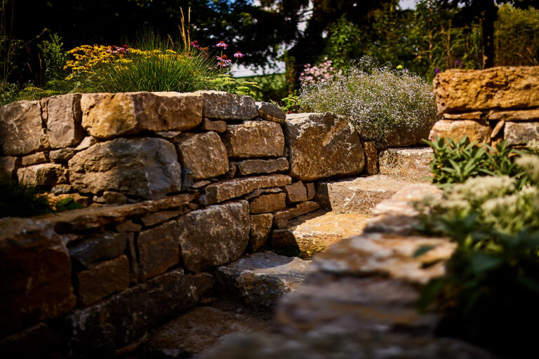 Treppe aus Naturstein zur Verbindung der Gartenbereiche