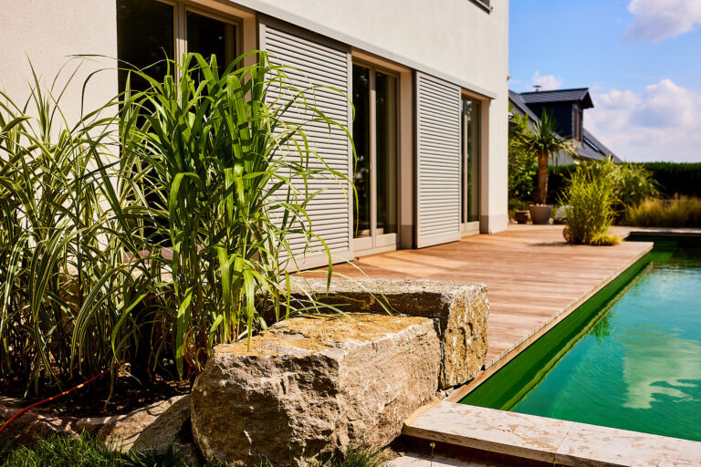 An den Naturpool angrenzende Holzterrasse