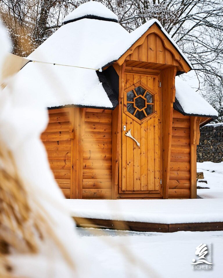 Saunahaus mit Gräsern im Schnee