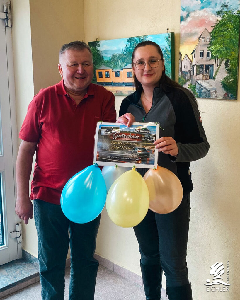Ariane Klemm überreicht Bernhard Eichler das Geschenk zu seinem 65 Geburtstag, Gutschein für ein Fahrsicherheitstraining am Sachsenring