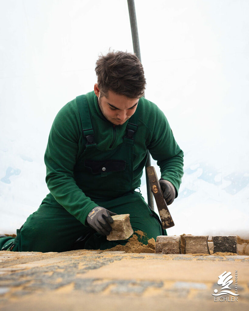 Eichler Gartenideen Azubi bei Pflasterarbeiten