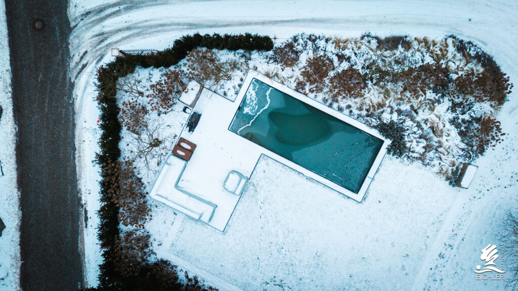 Drohnenaufnahme eines teilweise zugefrorenen Naturpools