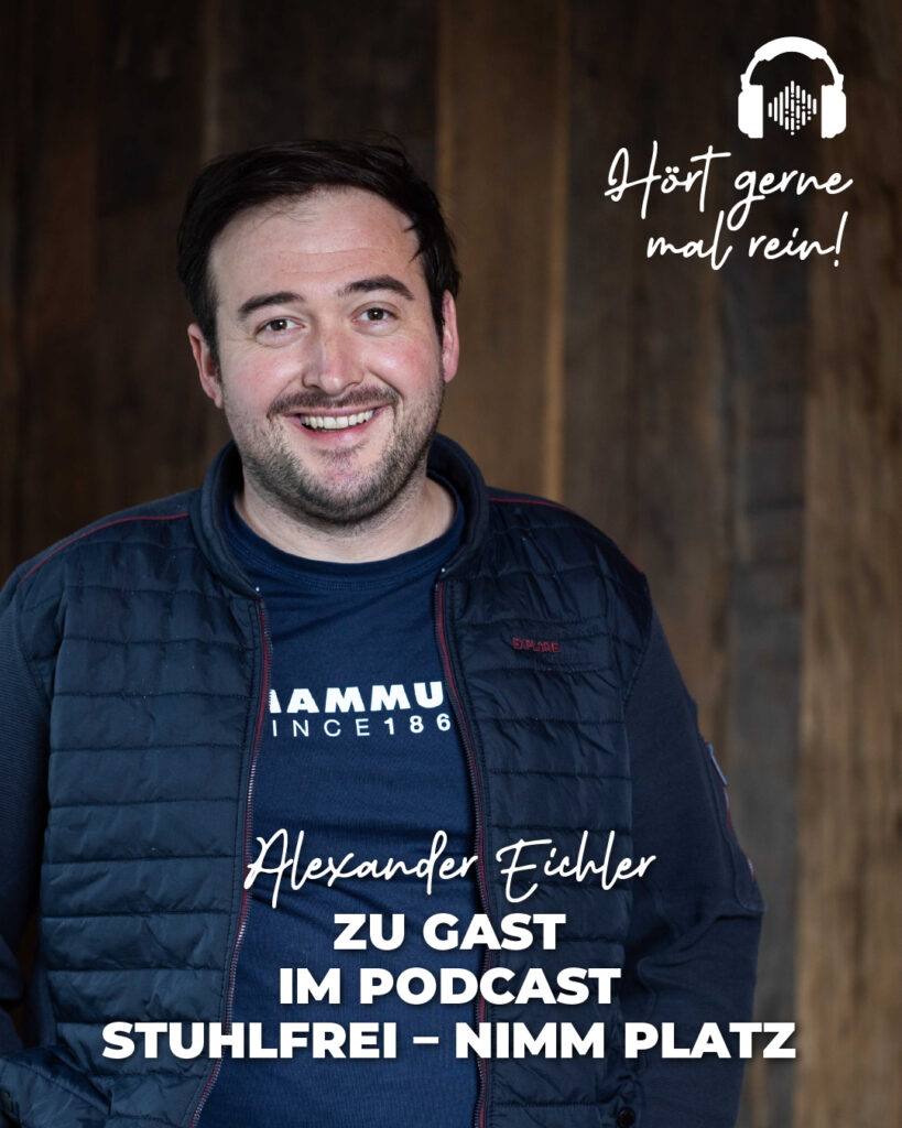 Alexander Eichler steht lächeln von einer Holzwand. Aufschrift auf dem Bild: Alexander Eichler zur Gast beim Podcast "Stuhlfrei". Hörn gerne rein.