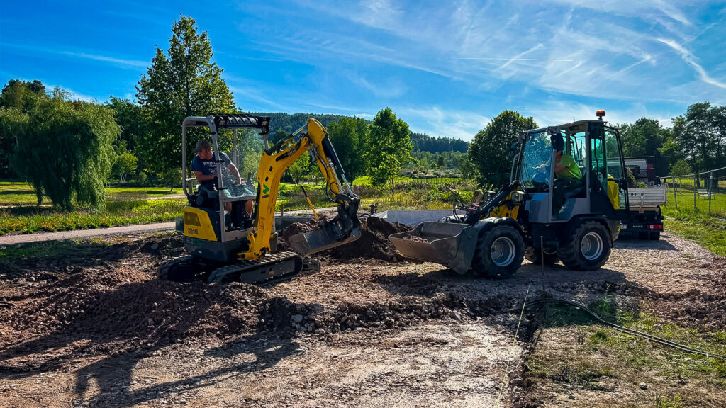 Bagger mit einem Azubi von Eichler Gartenideen auf der Azubiprojekt Baustelle